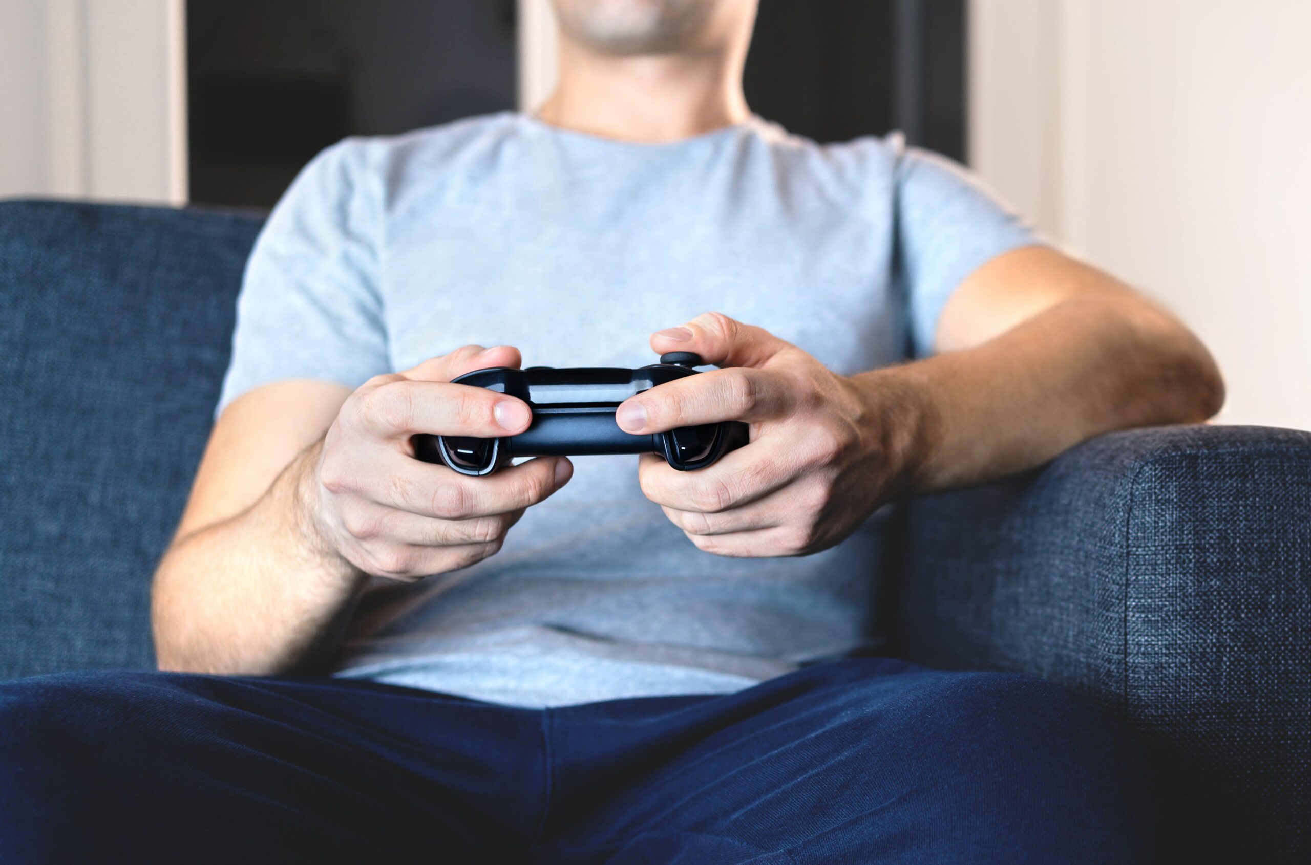a man in a grey shirt playing Syberia Remastered on his Playstation