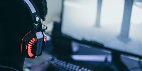 a person wearing headphones playing a S.T.A.L.K.E.R. 2 video game on their PC