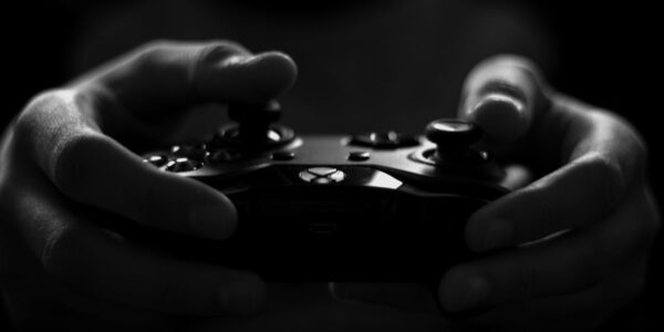 a person holding an X Box controller while playing The First Berserker: Khazan in the dark