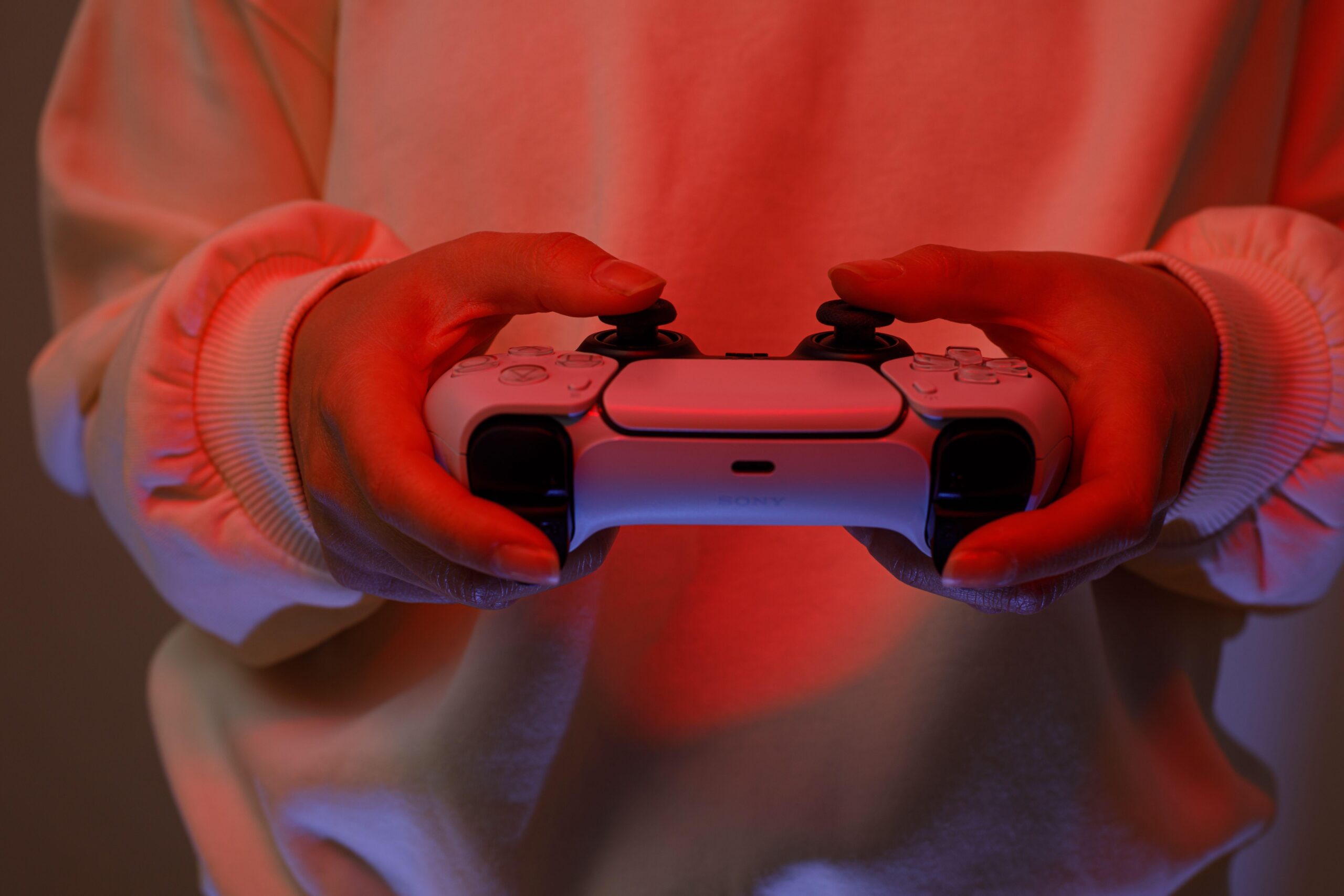 a person playing The Midnight Walk on Playstation 5 with red lights in the room